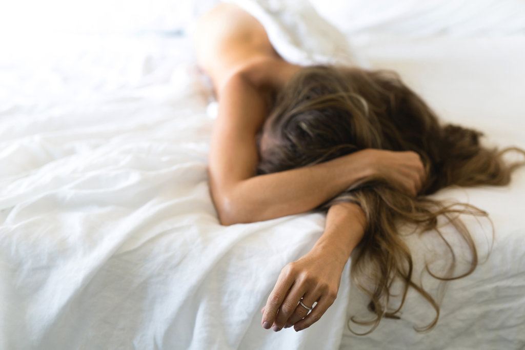 Kobieta z długimi włosami leżąca na łóżku 
