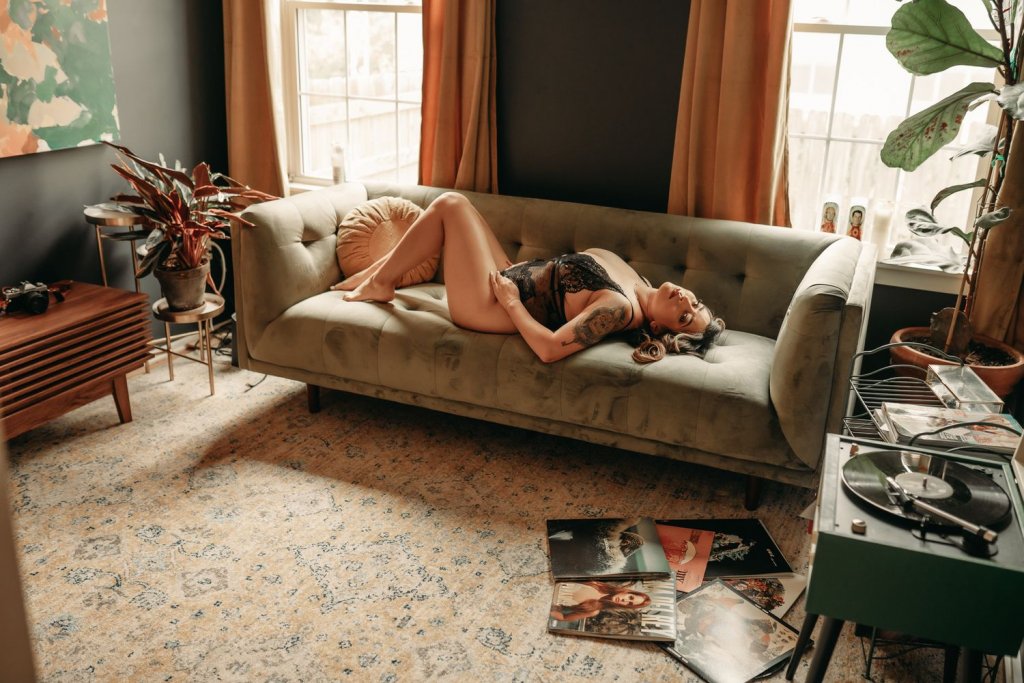 Kobieta w bieliźnie leżąca na sofie w pokoju, na podłodze płyty winylowe